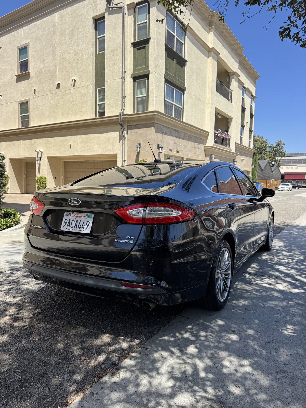 Black 2014 Ford Fusion Hybrid rear passenger-side three-quarter view