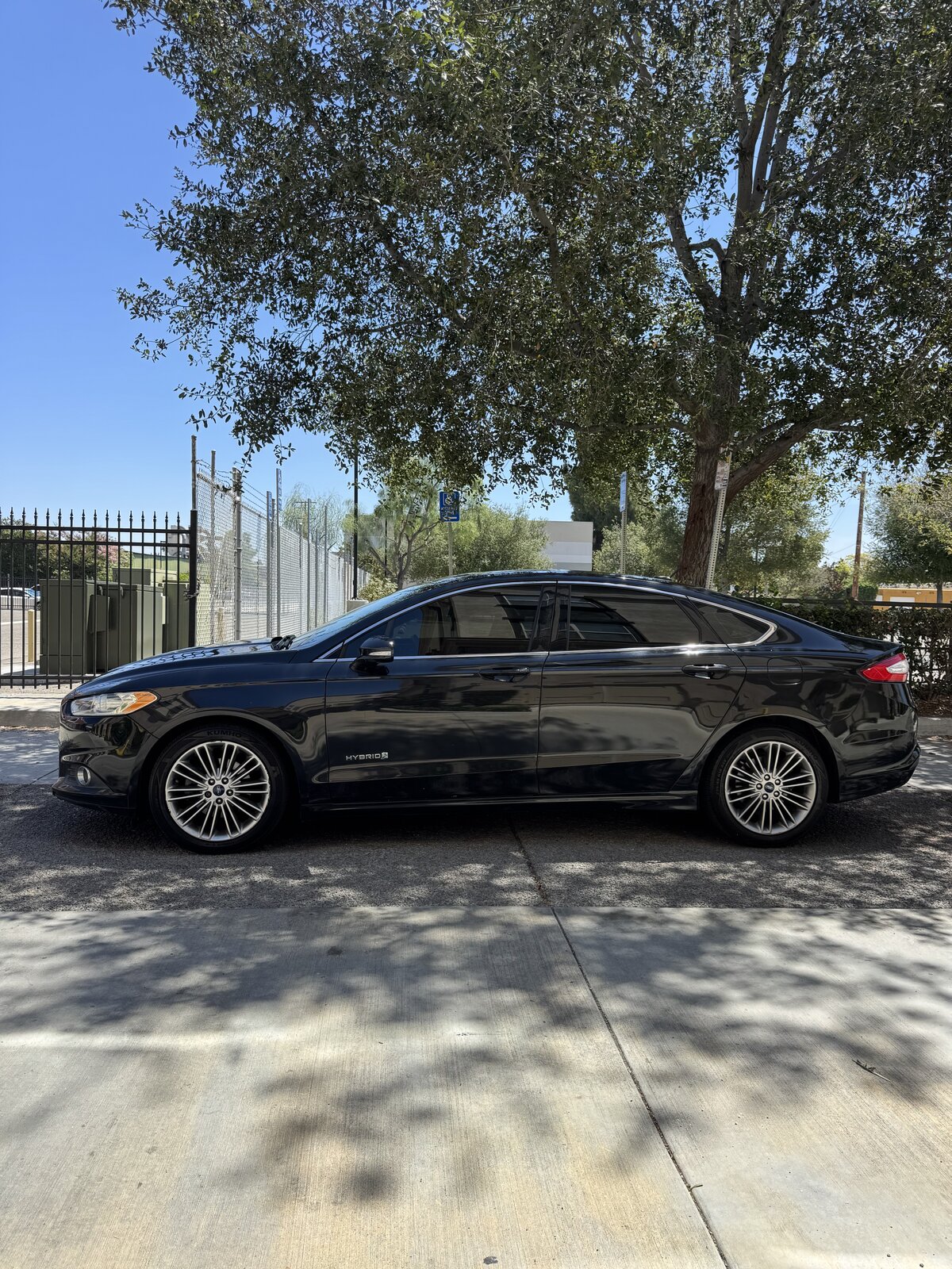 Black 2014 Ford Fusion Hybrid full driver-side profile view